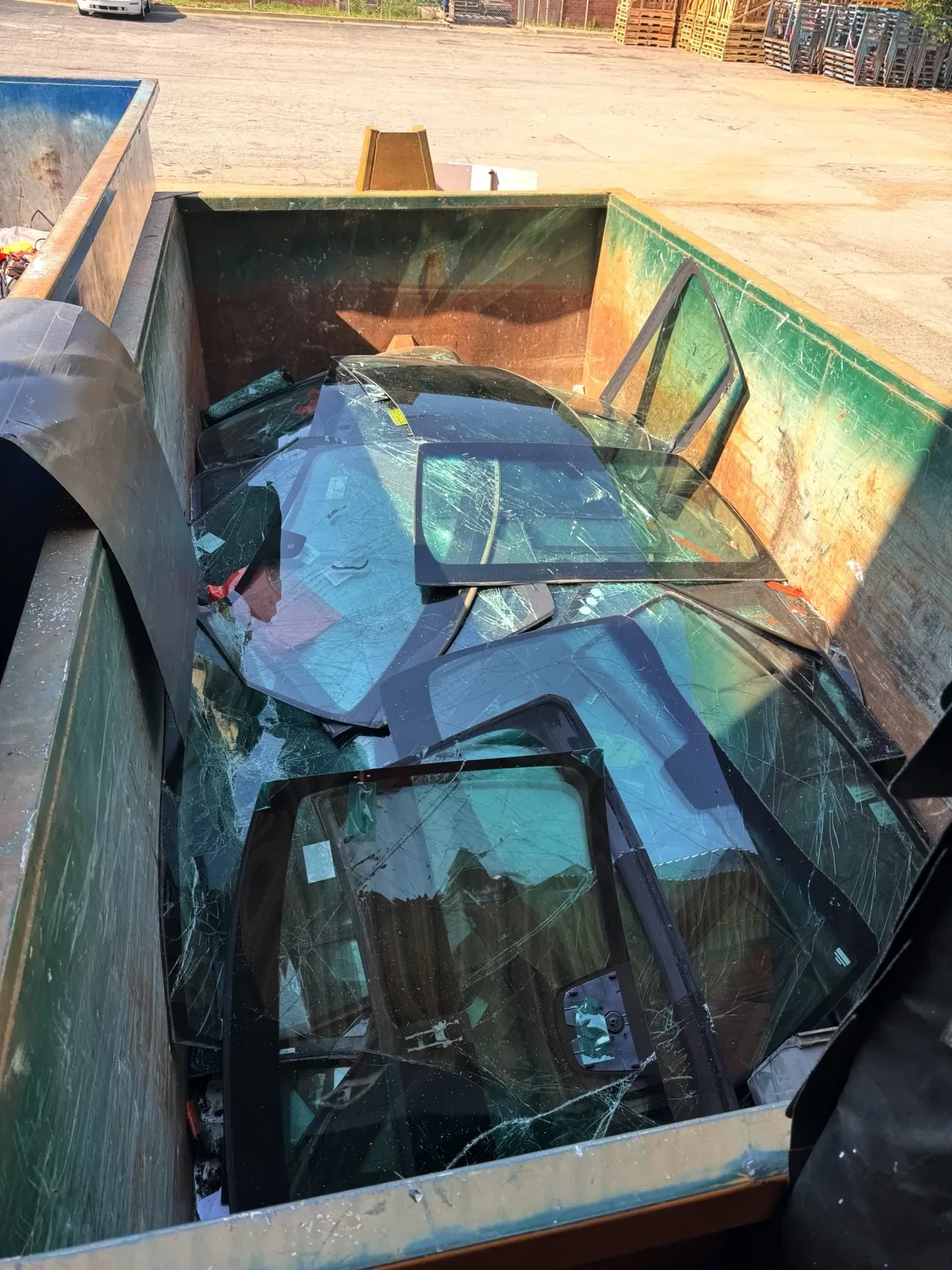 Removed vehicle glass collected for recycling after auto glass service