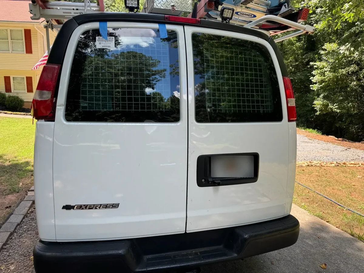 Chevy Express rear door glass after replacement with privacy plate blurred