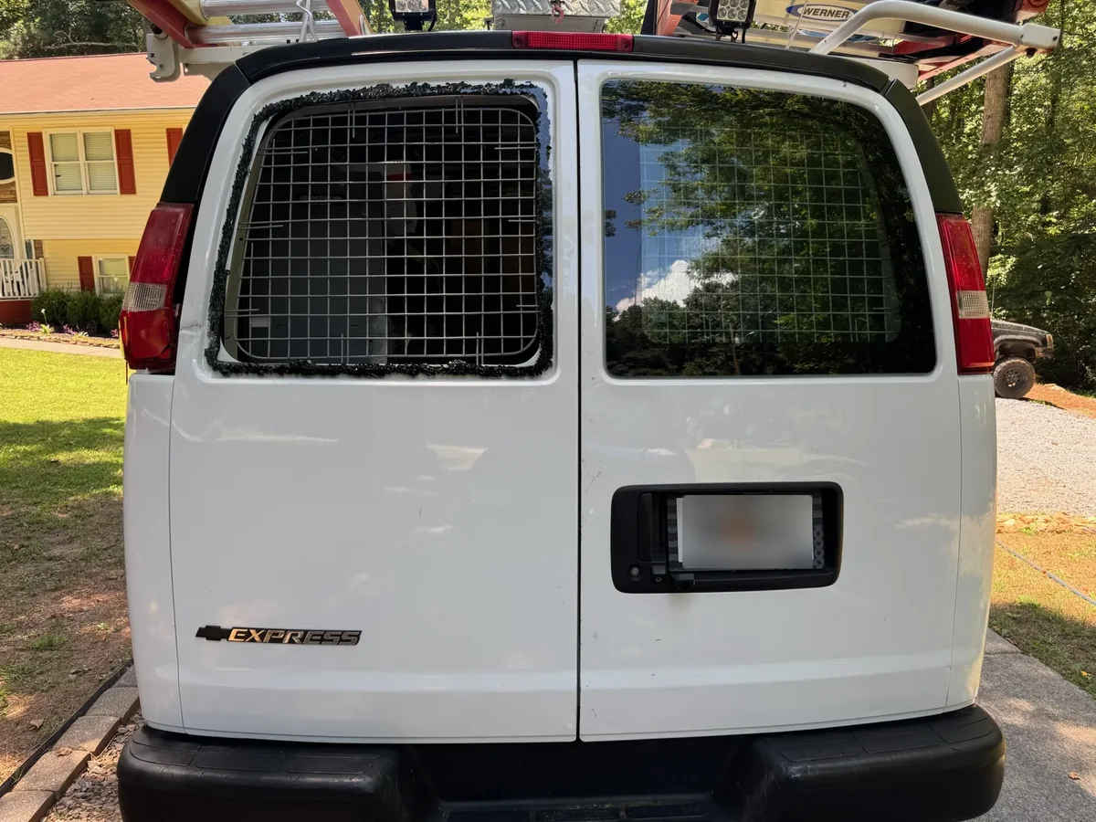 Chevy Express rear cargo door opening before glass replacement with privacy plate blurred
