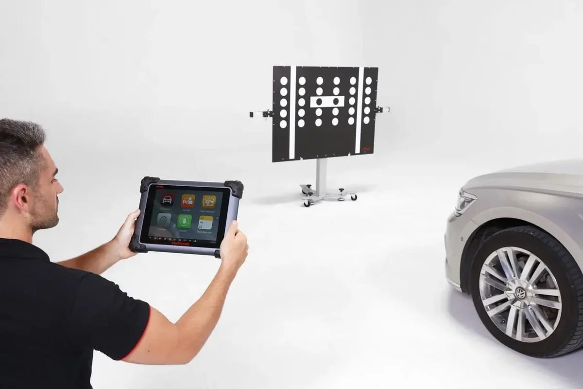 Technician using a diagnostic tablet during ADAS calibration