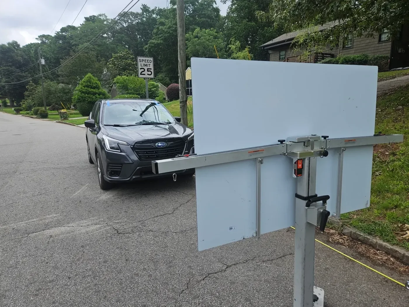 Mobile ADAS calibration target setup behind a Subaru in a residential driveway
