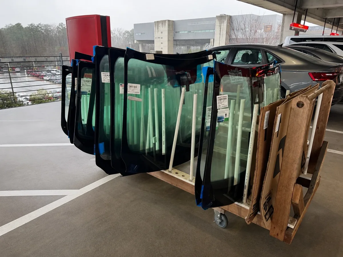 Replacement auto glass organized on a rack before installation